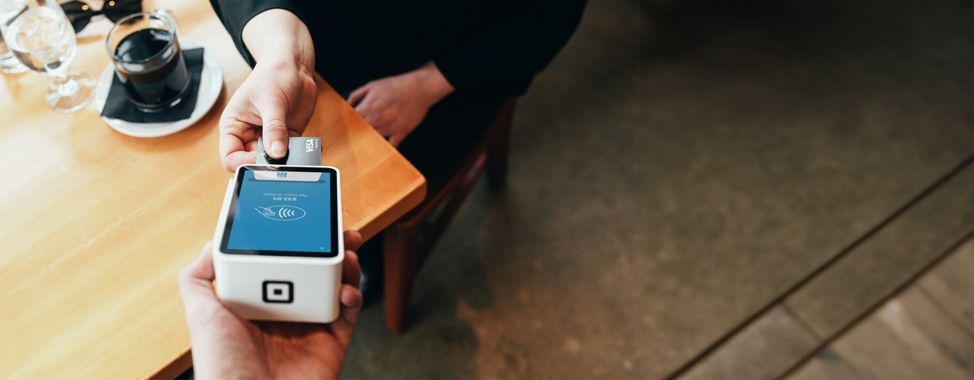 Máquina de cartão de crédito recebendo o pagamento na cafeteria.